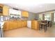 Bright kitchen with wooden cabinets, granite countertops, tile flooring and a breakfast bar seating area at 287 Ellenton Run, The Villages, FL 32162