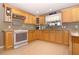Well-lit kitchen featuring wooden cabinets, granite countertops, and modern appliances for cooking needs at 287 Ellenton Run, The Villages, FL 32162