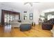 Bright living room featuring hardwood floors, neutral-toned furniture, and sliding glass doors at 287 Ellenton Run, The Villages, FL 32162