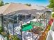Aerial view of the screened-in pool area with lush landscaping and a rock waterfall at 2894 Southern Pines Loop, Clermont, FL 34711