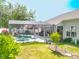 Green backyard with a screened-in pool, spa, rock waterfall, and lush landscaping at 2894 Southern Pines Loop, Clermont, FL 34711