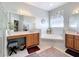 Bright bathroom with double vanities, a soaking tub, a large mirror, and neutral decor at 2894 Southern Pines Loop, Clermont, FL 34711