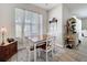 Cozy dining room with a wooden table, four chairs, sheer curtains, and ample natural light at 2894 Southern Pines Loop, Clermont, FL 34711