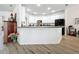 Open kitchen featuring a long breakfast bar, white cabinetry, a black refrigerator, and wood-look flooring at 2894 Southern Pines Loop, Clermont, FL 34711