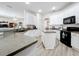 Bright kitchen features white cabinets, gray countertops, stainless steel appliances, and a convenient center island at 2894 Southern Pines Loop, Clermont, FL 34711
