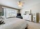 Serene main bedroom featuring a white bed, a palm leaf ceiling fan, and a large window for natural light at 2894 Southern Pines Loop, Clermont, FL 34711