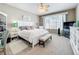 Comfortable main bedroom with a white bed, a bench, a ceiling fan, and a large window for natural light at 2894 Southern Pines Loop, Clermont, FL 34711