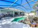 Screened-in pool area with rock waterfall feature and black safety fence at 2894 Southern Pines Loop, Clermont, FL 34711