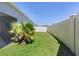 Green backyard featuring privacy fence and landscaping, accessible from screened lanai at 2919 Gulley Ln, The Villages, FL 32163