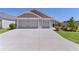 Spacious three-car garage with a wide driveway, perfect for parking multiple vehicles at 2919 Gulley Ln, The Villages, FL 32163