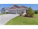Beautiful home with a three-car garage and nicely landscaped front yard at 2919 Gulley Ln, The Villages, FL 32163