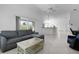 Open living room with tile floors, comfortable seating, and an open view to the kitchen at 2919 Gulley Ln, The Villages, FL 32163