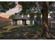 Spacious backyard with mature trees, patio area, and screened porch for outdoor enjoyment at 30236 Pga Dr, Sorrento, FL 32776