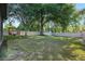 Large backyard with mature trees, a shed, a firepit area, and a white fence at 30236 Pga Dr, Sorrento, FL 32776