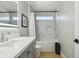 Well-lit bathroom with grey vanity, modern fixtures, and a tub-shower combo with tiled surround at 30236 Pga Dr, Sorrento, FL 32776