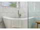 Modern bathroom featuring a soaking tub, marble tiling, and a glass-enclosed shower at 30236 Pga Dr, Sorrento, FL 32776