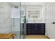 Stylish bathroom featuring marble tile in shower, modern blue vanity, and elegant fixtures at 30236 Pga Dr, Sorrento, FL 32776