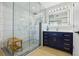 Modern bathroom featuring a glass enclosed shower, a vanity with white countertop and gold hardware, and marble-look tile at 30236 Pga Dr, Sorrento, FL 32776