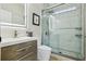 Modern bathroom featuring an LED mirror, floating wood vanity, and glass shower with marble tile at 30236 Pga Dr, Sorrento, FL 32776