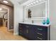 Bright bathroom featuring a modern vanity with gold hardware, blue decor, and an arched entry to the walk-in closet at 30236 Pga Dr, Sorrento, FL 32776
