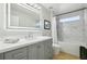 Bright bathroom with grey vanity, sleek fixtures, and a shower-tub combination with marble tile at 30236 Pga Dr, Sorrento, FL 32776
