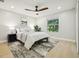 Cozy bedroom with neutral tones, wood-look floors, ceiling fan, and a bright window view at 30236 Pga Dr, Sorrento, FL 32776