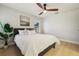 Bright bedroom with a ceiling fan, hardwood floors, and a comfortable bed with stylish accents at 30236 Pga Dr, Sorrento, FL 32776