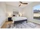 Bright bedroom featuring a ceiling fan, a plush rug, natural light, and a queen bed with nightstands at 30236 Pga Dr, Sorrento, FL 32776