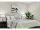 Bright bedroom featuring a bed with decorative pillows and a nightstand with a lamp and leafy plant at 30236 Pga Dr, Sorrento, FL 32776