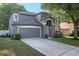 Two-story home featuring a well-manicured lawn, gray siding, white trim, and a two car garage at 30236 Pga Dr, Sorrento, FL 32776
