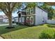 Landscaped corner lot with a two-story home featuring gray siding, white trim, and a well-manicured lawn at 30236 Pga Dr, Sorrento, FL 32776