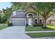 Charming two-story home featuring a well-manicured lawn, gray siding and a two car garage at 30236 Pga Dr, Sorrento, FL 32776