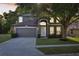 Charming home exterior with manicured lawn, large tree, and inviting entrance at 30236 Pga Dr, Sorrento, FL 32776