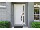 Close-up of the front door area featuring a white door with a side window at 30236 Pga Dr, Sorrento, FL 32776