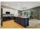 Open kitchen featuring a large center island, stainless appliances, and light wood flooring at 30236 Pga Dr, Sorrento, FL 32776