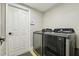 This laundry room features a full-size Samsung washer and dryer, a door, and neutral paint throughout at 30236 Pga Dr, Sorrento, FL 32776