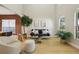 Bright living room with high ceilings, light wood floors, and a variety of seating options at 30236 Pga Dr, Sorrento, FL 32776