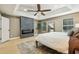 Spacious main bedroom offering a stone fireplace, light hardwood floors, and a view of the windows and the ceiling fan at 30236 Pga Dr, Sorrento, FL 32776