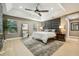 Spacious main bedroom featuring a padded headboard, a ceiling fan, and light wood floors throughout at 30236 Pga Dr, Sorrento, FL 32776