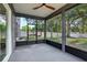 Enclosed porch with neutral tones, ceiling fan, and views of the backyard and firepit area at 30236 Pga Dr, Sorrento, FL 32776