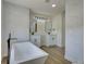 Bright bathroom featuring a modern soaking tub, double vanities, and marble-look tile at 307 Big Black Ln, Poinciana, FL 34759