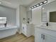 Bright bathroom featuring a freestanding tub, double sinks, marble tile, and modern fixtures at 307 Big Black Ln, Poinciana, FL 34759