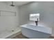 Luxurious bathroom featuring a freestanding tub and glass-enclosed shower with marble tile at 307 Big Black Ln, Poinciana, FL 34759