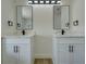 Bright bathroom featuring a modern double vanity with black fixtures and wood-look floors at 307 Big Black Ln, Poinciana, FL 34759