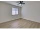 Clean, minimalist bedroom with wood-look flooring, a window, and a modern ceiling fan at 307 Big Black Ln, Poinciana, FL 34759