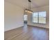 Bright dining area with wood floor, stylish chandelier and natural light from the window at 307 Big Black Ln, Poinciana, FL 34759
