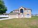 Inviting two-story home showcasing a well-manicured lawn and a two-car garage at 307 Big Black Ln, Poinciana, FL 34759