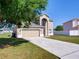 Inviting two-story home showcasing a well-manicured lawn and a two-car garage at 307 Big Black Ln, Poinciana, FL 34759