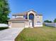 Inviting two-story home showcasing a well-manicured lawn and a two-car garage at 307 Big Black Ln, Poinciana, FL 34759