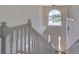 Foyer view from upstairs, featuring a hanging light fixture, a large window, and a staircase at 307 Big Black Ln, Poinciana, FL 34759
